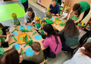 Dzieci wspólnie z rodzicami wykonują prace plastyczną "Kula ziemska"